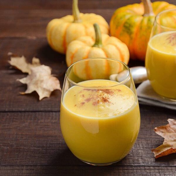 Two glasses of Pumpkin Spice Smoothie on a wooden surface