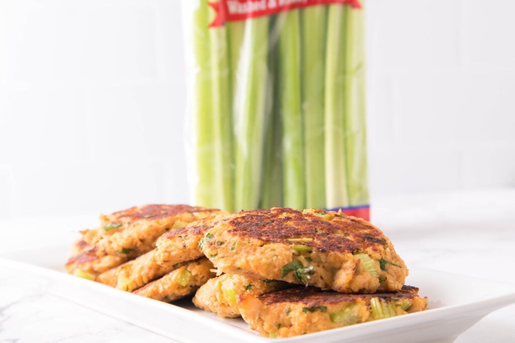 Crab cakes on a plate with celery in the background