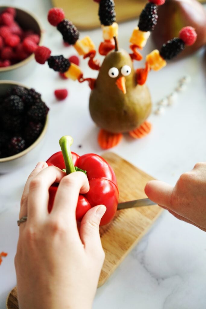 cutting into a bell pepper on a cutting board