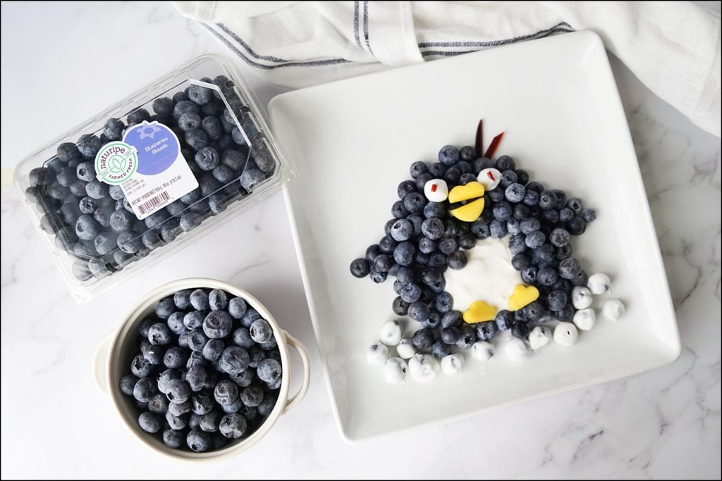 naturipe blueberries with penguin made from blueberries on white plate