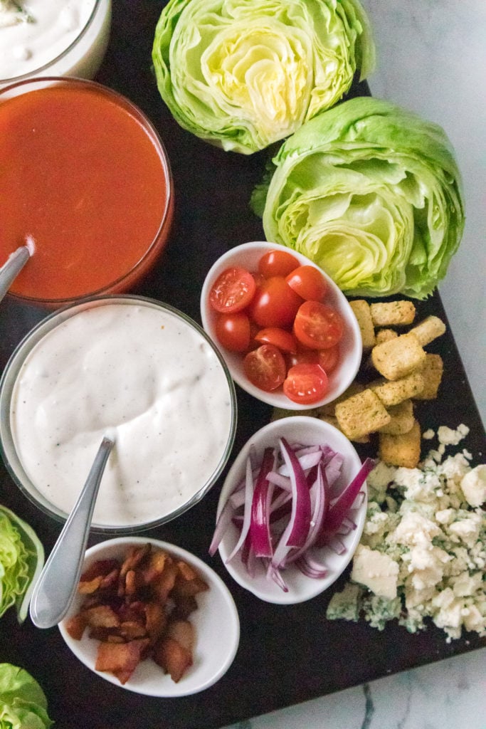 close up view of dressings and ingredients on wedge salad board