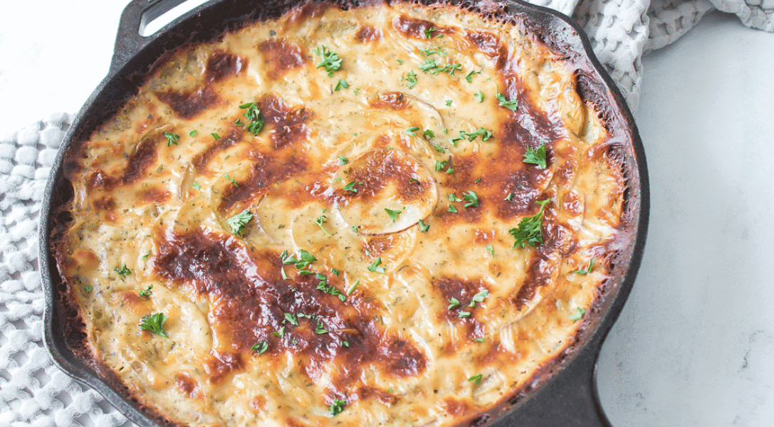 Cheesy Au Gratin Potatoes in cast iron skillet