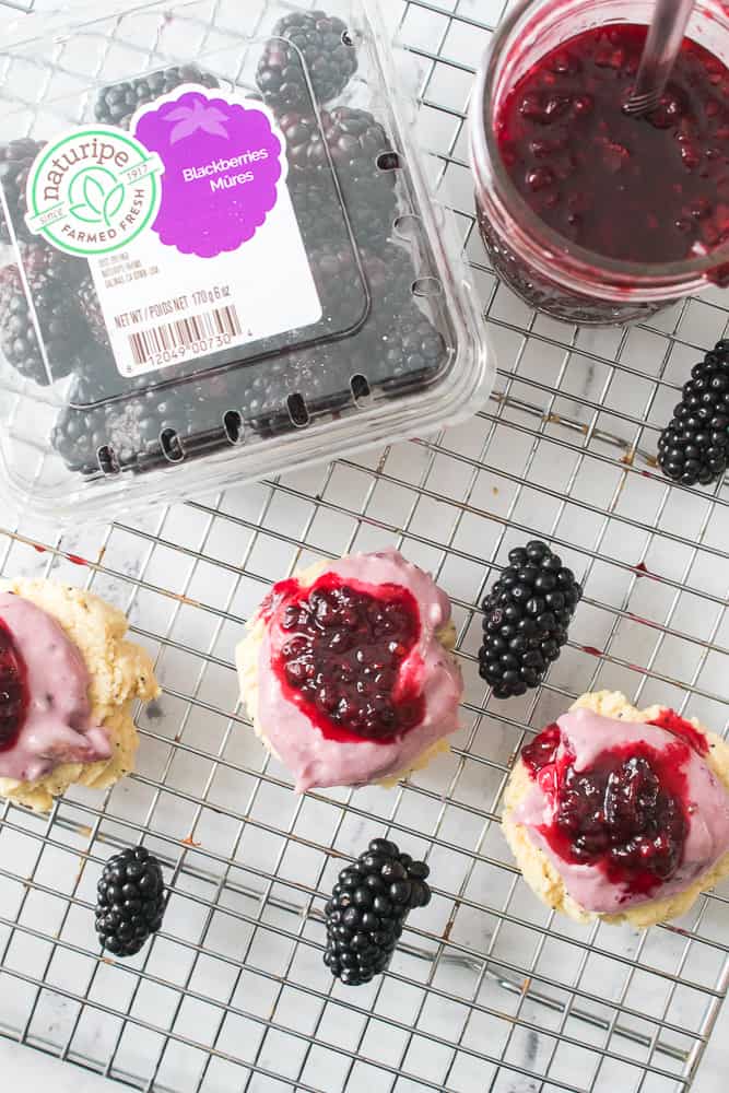 Topping the cookies with the blackberry cream cheese frosting and blackberry jam