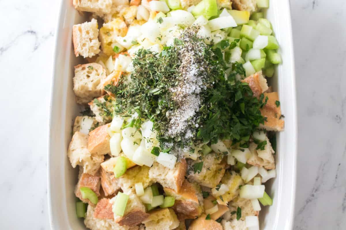 overhead shot of ingredients in casserole dish for homemade stuffing recipe