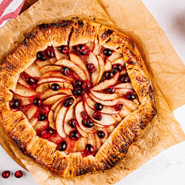 Overhead view of Cranberry Apple Galette with Envy™ apples and bowl of cranberries