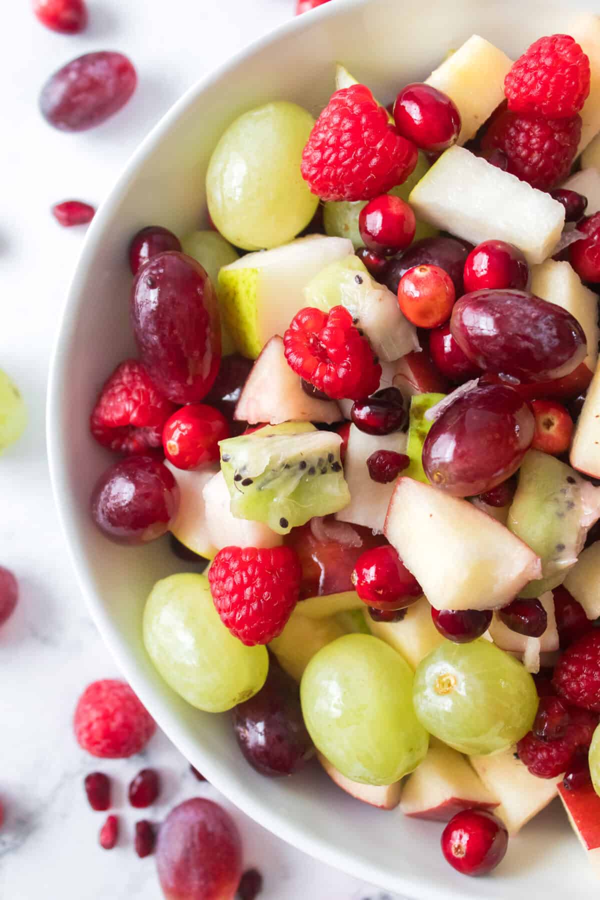 overhead vertical close up shot of christmas fruit salad in serving bowl