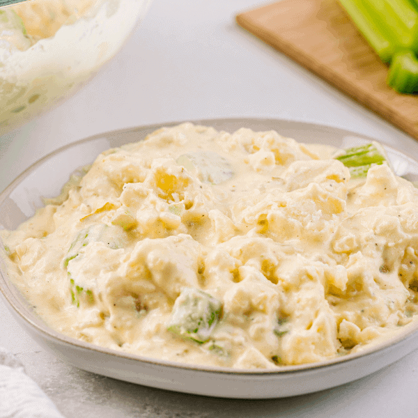 Old Fashioned Potato Salad on plate with cut celery on board in background