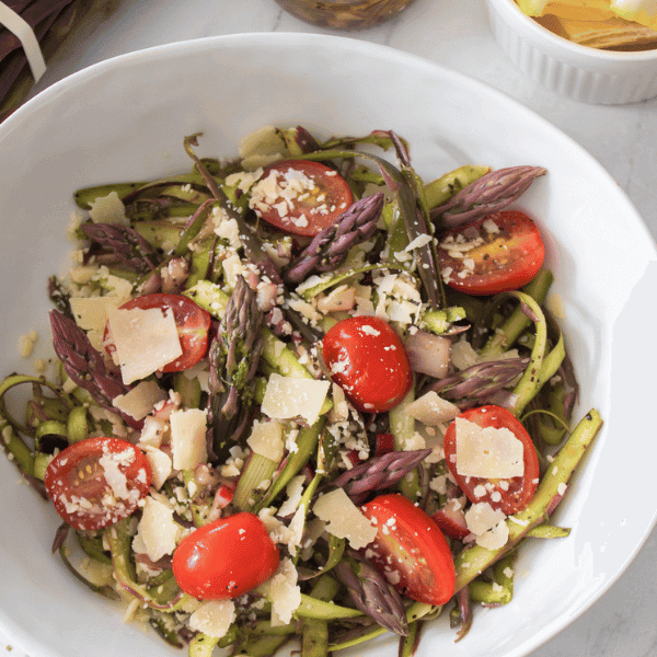 Shaved Asparagus Salad in white bowl with purple asparagus