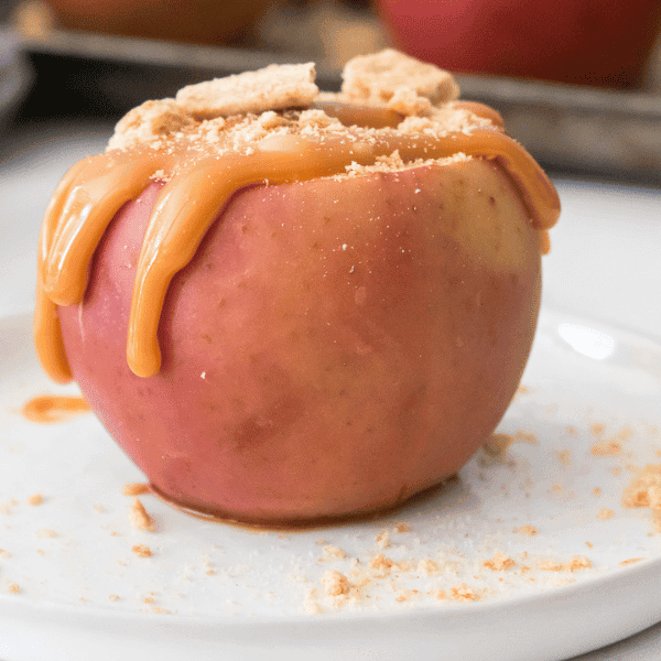 close up of cheesecake stuffed baked apple on a white plate