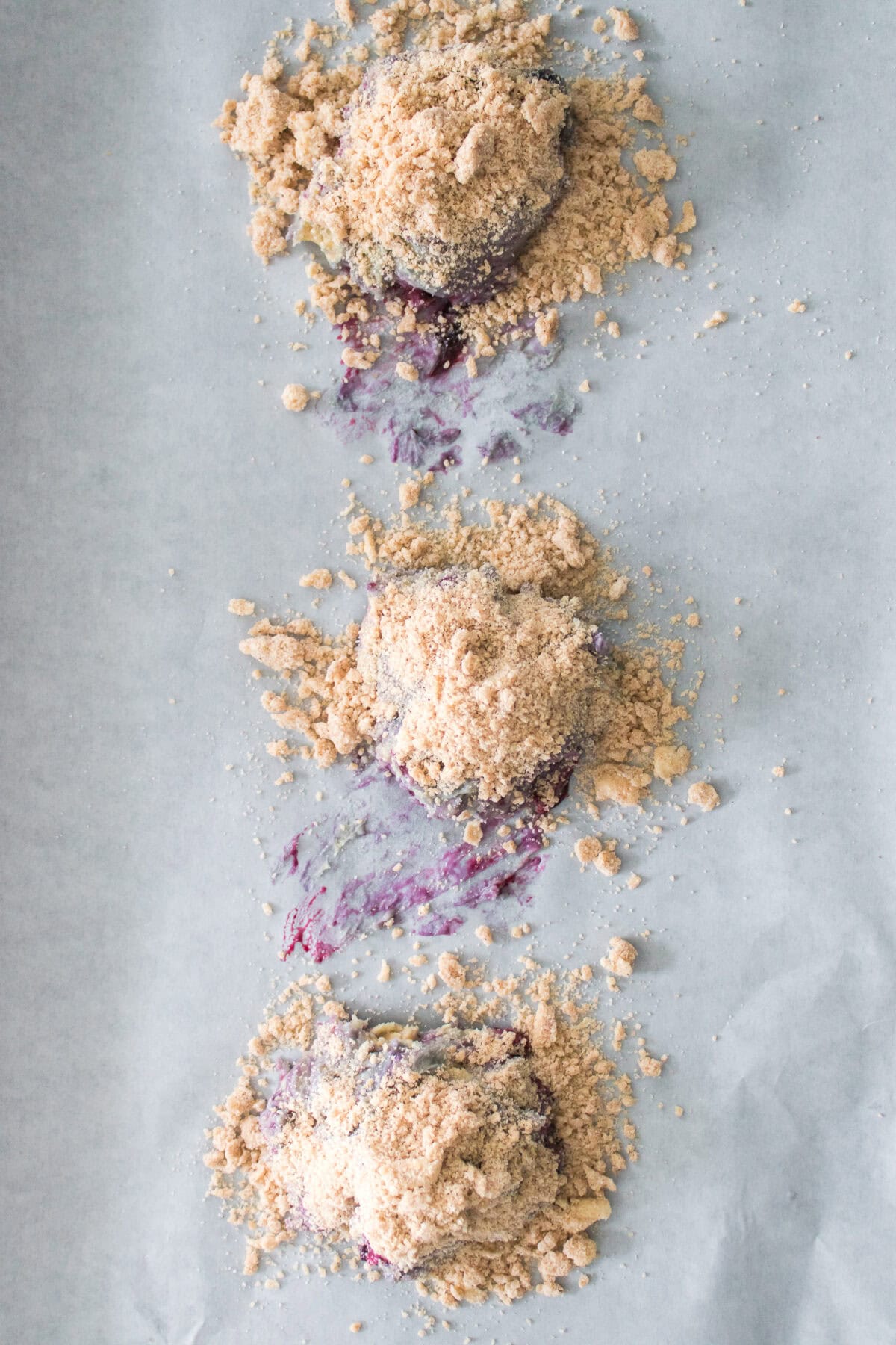 Homemade Copycat Crumbl Blueberry Muffin Cookies on baking sheet topped with streusel topping before being baked