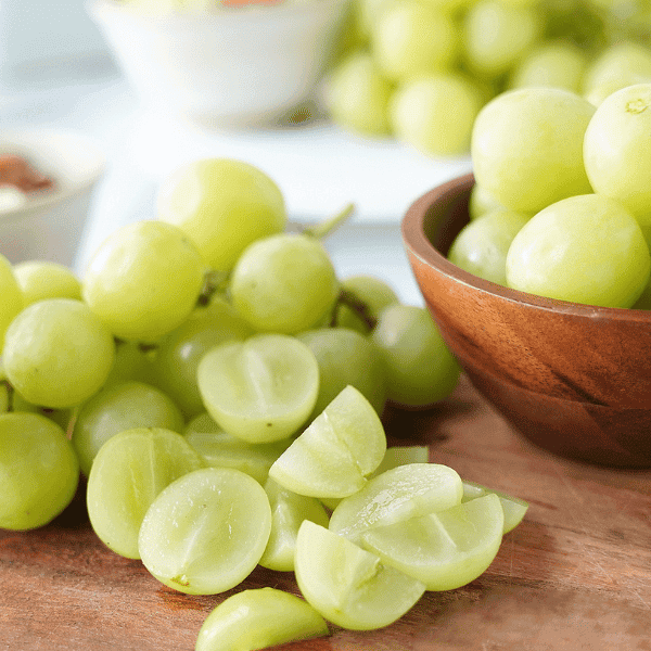 Green grapes in bowl and on cutting board