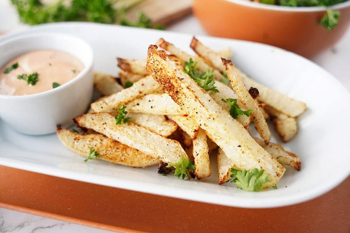 Jicama fries on white plate with dip