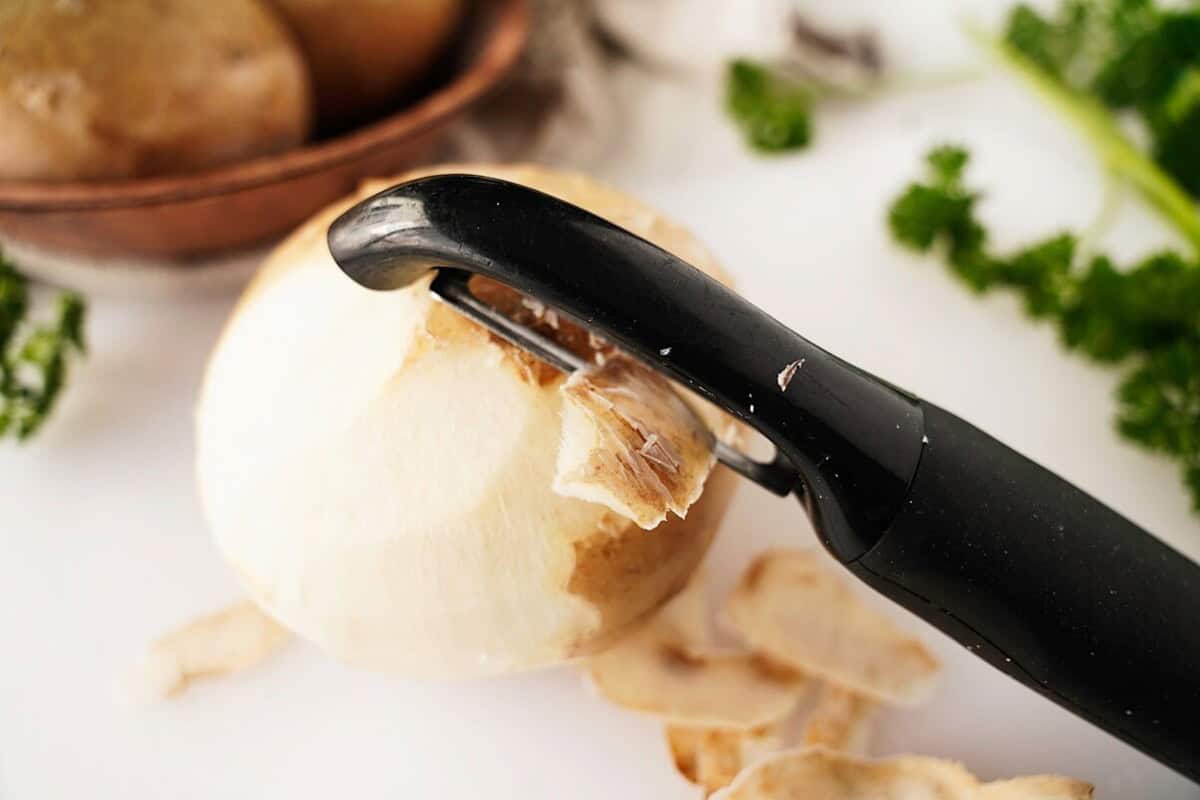 Peeling jicama with vegetable peeler